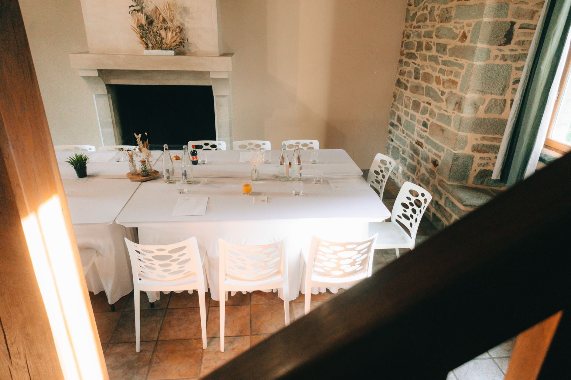 Beautifully set dining area with white chairs and table in a cozy room.